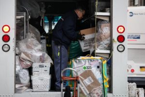 A United States Postal Service (USPS) mail delivery person prepares for deliveries in New York