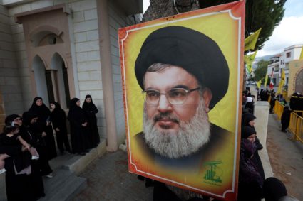 People stand near a picture of Hezbollah leader Sayyed Hassan Nasrallah in Kfar Melki