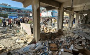 Palestinians inspect a school sheltering displaced people, after it was hit by an Israeli strike, amid the Israel-Hamas co...