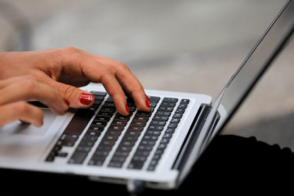 A person types on a laptop computer in Manhattan, New York City