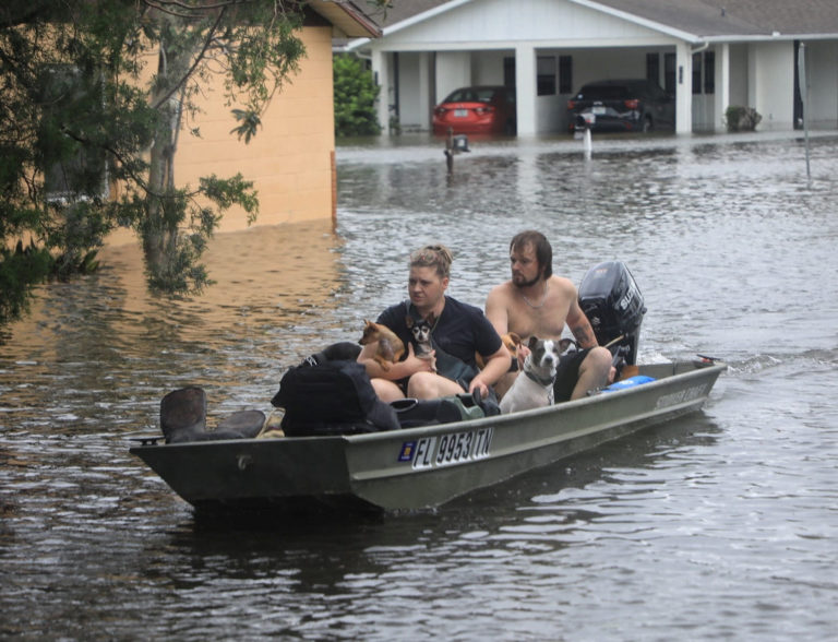 Residents and their pets evacuate Magnolia Avenue after Hurricane Milton flooded the neighbourhood in South Daytona