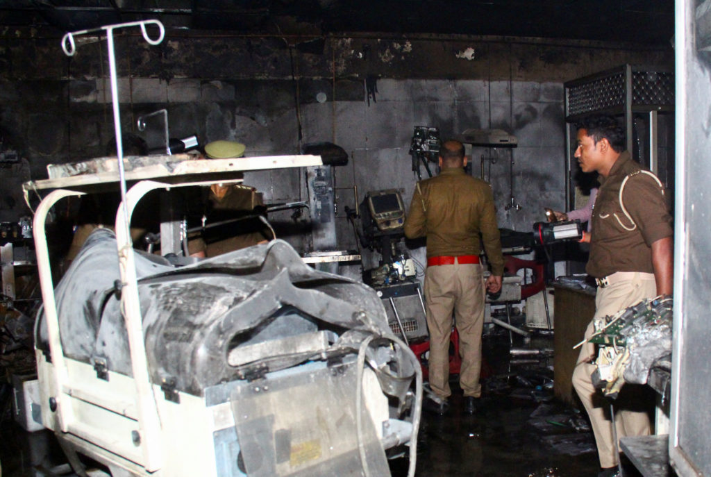 Police officers examine the damaged neonatal intensive care unit after a fire broke out at the Maharani Laxmibai Medical C...