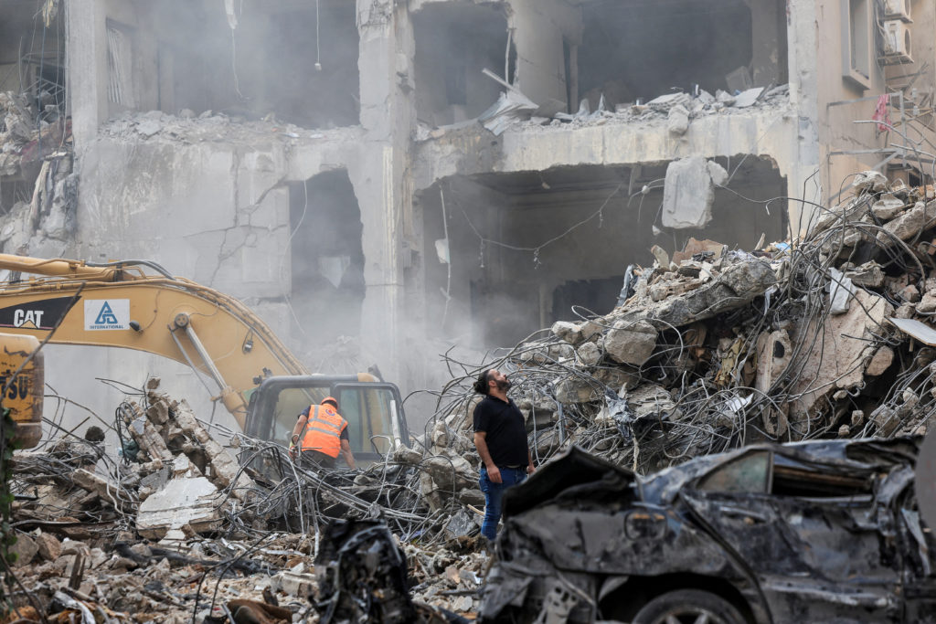 Civil defense members and rescuers work at the site of an Israeli strike in Beirut