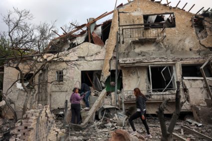 People check their family's damaged house at the scene where one of the projectiles fell, after they crossed over to Israe...
