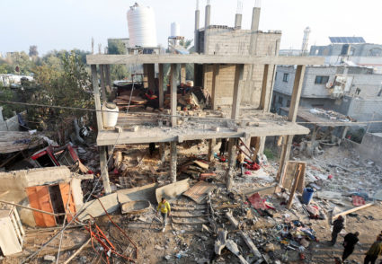 Palestinians inspect damage at the site of an Israeli strike in the central Gaza Strip