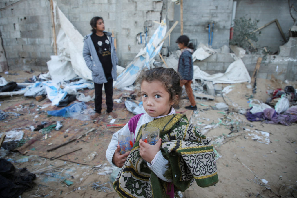 Palestinians inspect the damage at a tent camp sheltering displaced people, following an Israeli strike, in Khan Younis, s...