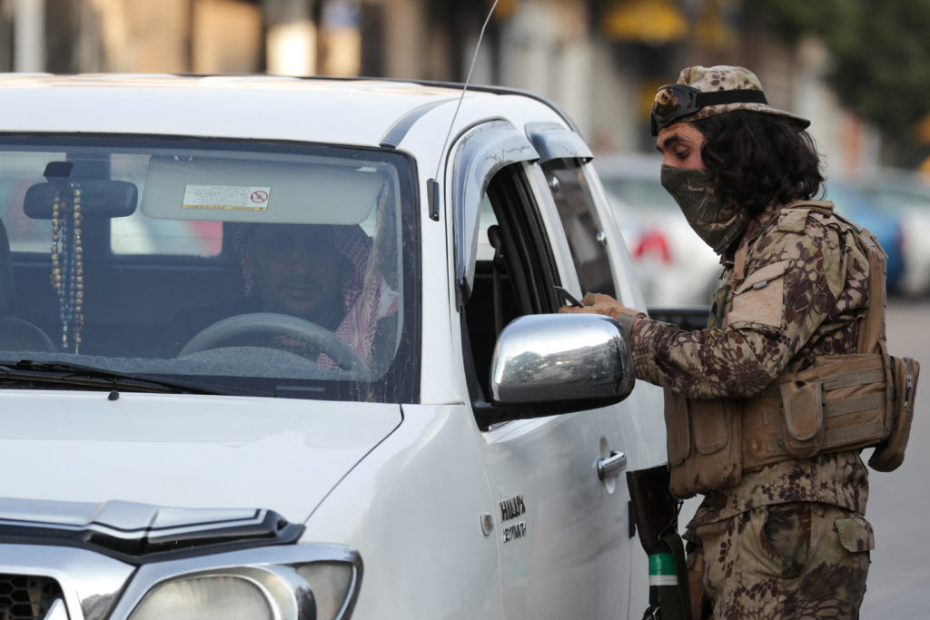 Fighters of the ruling Syrian body patrol after dissent surfaced in the city of Homs