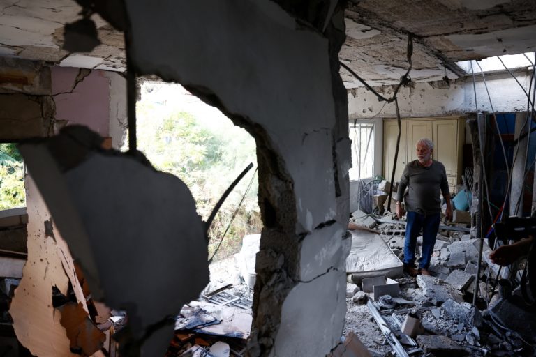 Yitzhak Moyal inspects his neighbor's apartment that was damaged after projectiles crossed over to Israel from Lebanon, in...