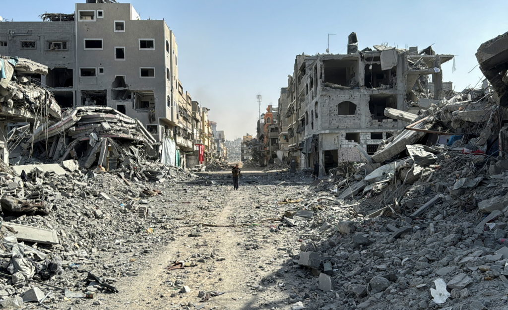 A Palestinian man walks past the rubble after Israeli forces withdrew from the area around Kamal Adwan hospital, amid the ...