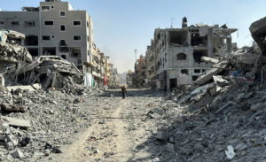 A Palestinian man walks past the rubble after Israeli forces withdrew from the area around Kamal Adwan hospital, amid the ...