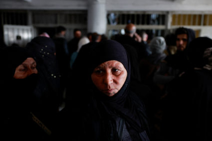 Members of the Syrian civil defence group, White Helmets, along with people search Sednaya prison