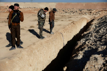 Fighters of the ruling Syrian body inspect the site of a mass grave from the rule of Syria's Bashar al-Assad, in Najha