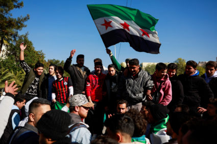 People damage a statue of the late Syria's President Hafez al-Assad, father of Bashar al-Assad, in Damascus