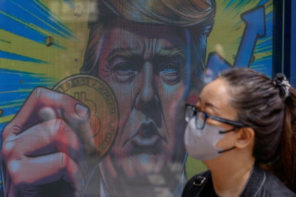 An illustration featuring U.S. President-elect Donald Trump holding Bitcoin is displayed outside a cryptocurrency exchange...