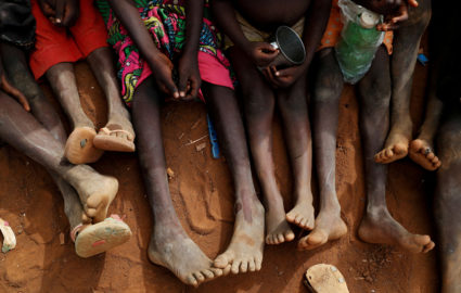 FILE PHOTO: Internally displaced orphans from Kadugli gather to eat boiled leaves at an IDP camp in South Kordofan, Sudan