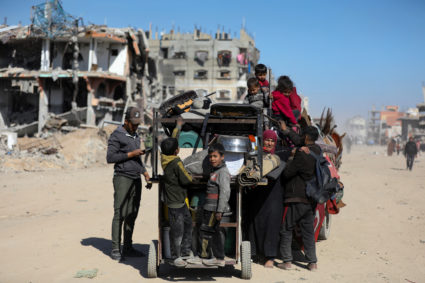 Palestinians make their way past the rubble of destroyed houses and buildings in Jabalia