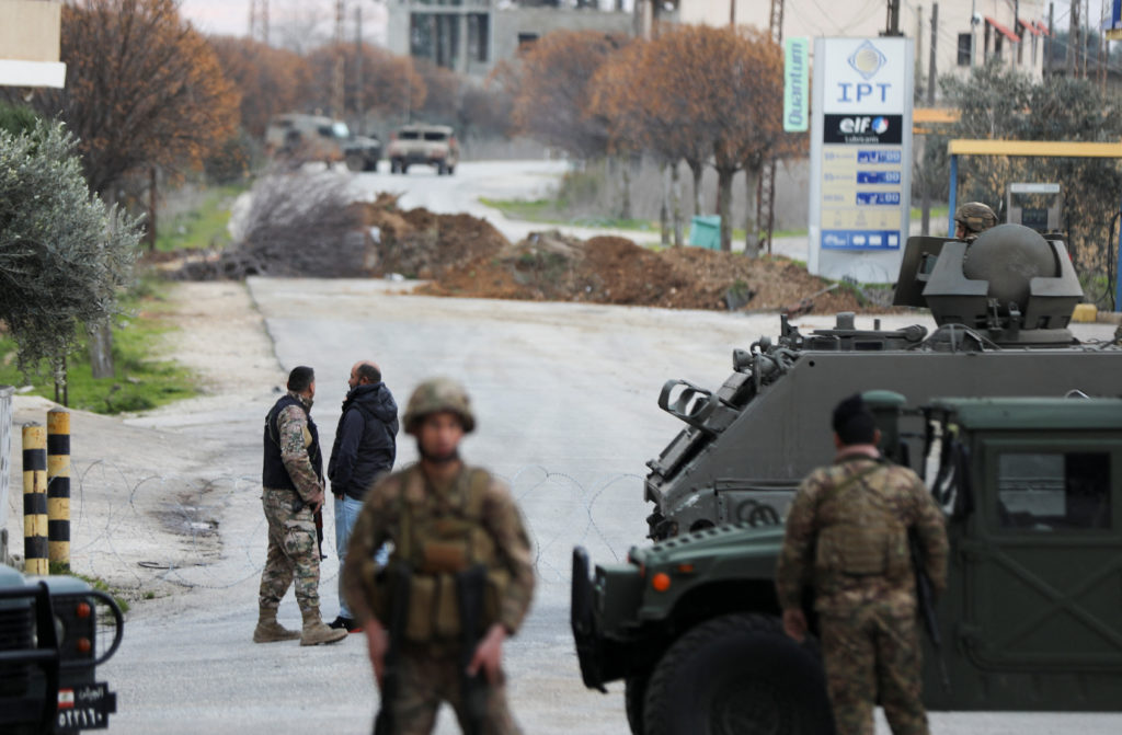 Lebanese army members secure the area as Israeli military vehicles are seen in the background, in Burj al-Muluk, near the ...