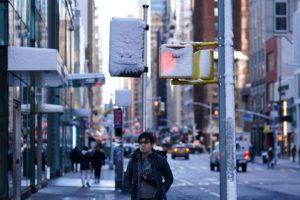 A person waits to cross the road, in New York