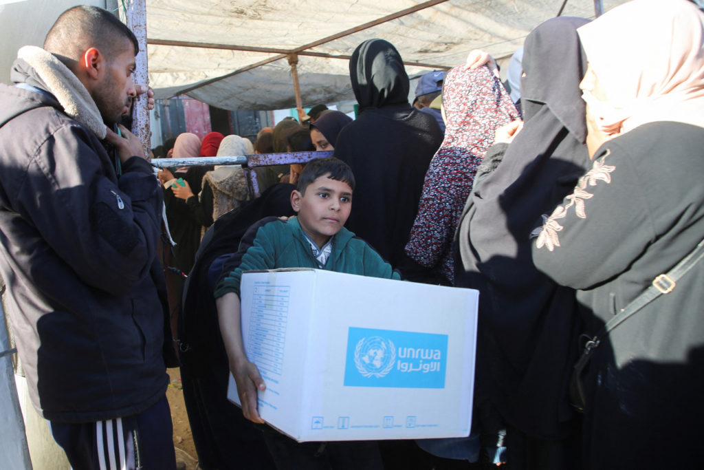 Palestinians receive aid following a ceasefire between Israel and Hamas, in Khan Younis in the southern Gaza Strip