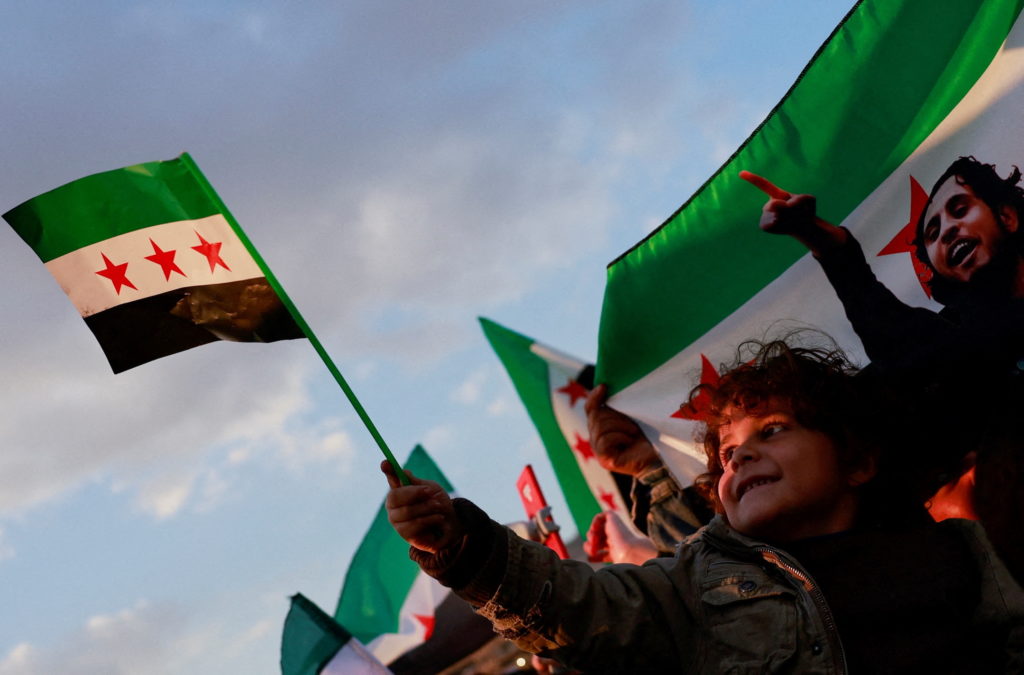 People gather during a celebration called by Hayat Tahrir al-Sham (HTS) after the ousting of Syria's Bashar al-Assad, in D...