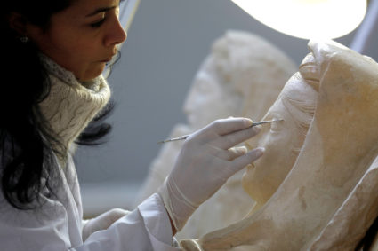 A specialist works on a damaged statue from Palmyra at Syria's National Museum of Damascus