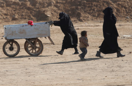 FILE PHOTO: Women and children walk through al-Hol camp in Syria
