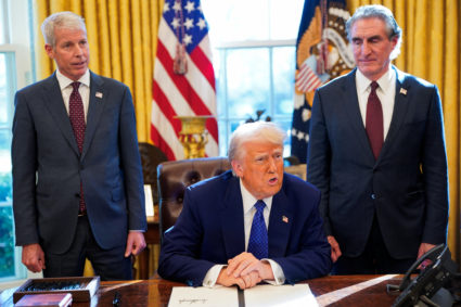 U.S. President Donald Trump signs an executive order in the Oval Office at the White House in Washington, D.C.