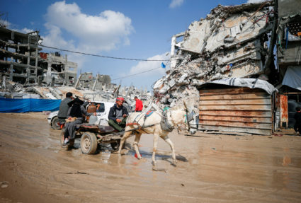 Palestinians gather around rubble of buildings destroyed during the Israeli offensive, in northern Gaza