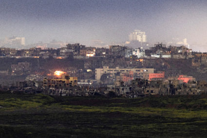 Fire burns in damaged houses, amid a ceasefire between Hamas and Israel, as seen from the Israeli side of the border