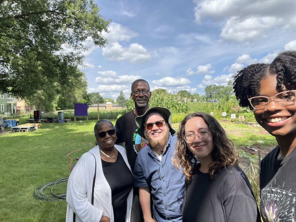 Five people standing at a community farm in Ypsilanti, Michigan.