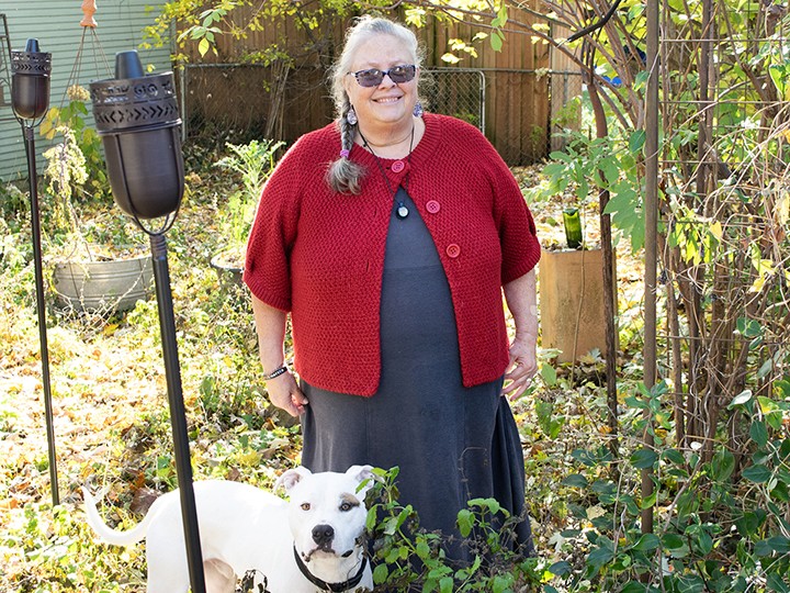 woman and dog standing in garden 