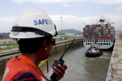 FILE PHOTO: A worker talks on a walkie talkie as cargo ship named Cosco Houston, navigates through Cocoli locks during a t...