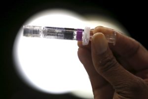 A nurse displays a flu vaccine at a free medical and dental health clinic in Los Angeles