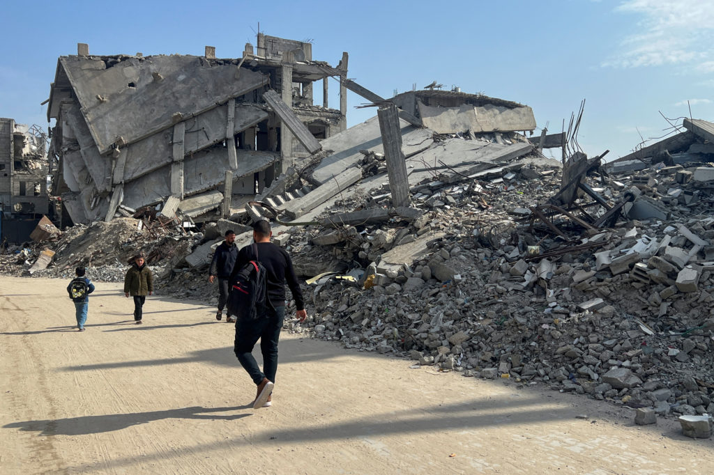 Palestinians walk past the rubble of destroyed houses, amid a ceasefire between Israel and Hamas, in Khan Younis in the so...