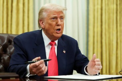 FILE PHOTO: U.S. President Donald Trump signs executive orders in the Oval Office, at the White House in Washington, D.C.