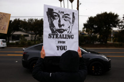 People protest against Tesla and Elon Musk outside a Tesla dealership in Los Angeles
