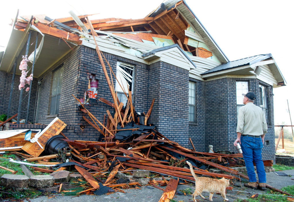 Kerry Walker checks the storm damage of his home after a fatal overnight tornado hit the area in Alabama