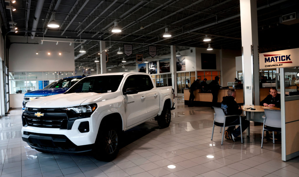 An auto salesman helps a customer in a Chevrolet dealership in Redford Township, Michigan,