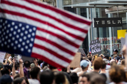 People protest against Tesla and its CEO Elon Musk outside a Tesla store in New York