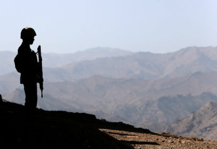 A soldier stands guard along the border fence outside the Kitton outpost on the border with Afghanistan in North Waziristan