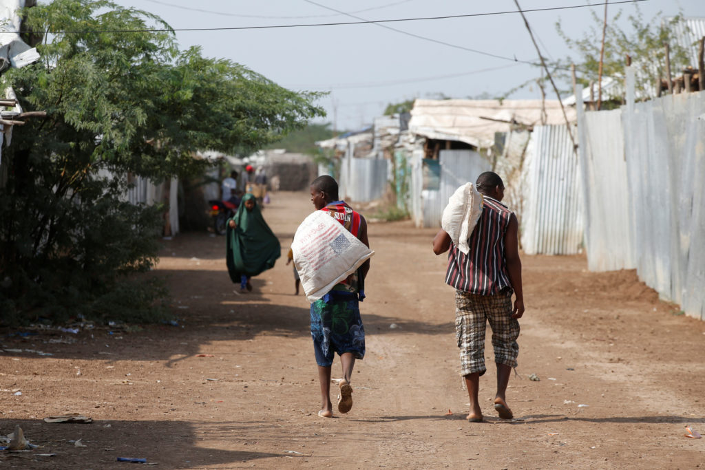 Men carry bags of food aid at the Kakuma refugee camp in northern Kenya