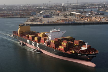 A container ship is guided by tugboats out of the terminal at the Port of Long Beach-Port of Los Angeles complex, amid the...