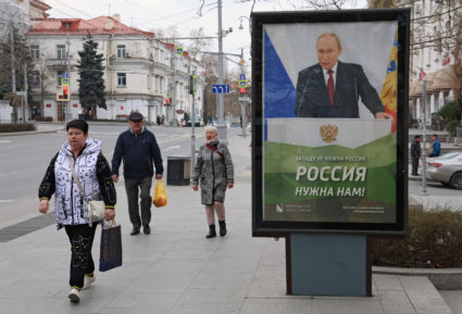 People walk past a banner depicting Russian President Putin in Sevastopol