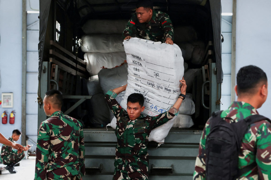 Indonesian military officers unload logistical aid for earthquake victims in Myanmar from a truck at the warehouse at Hali...