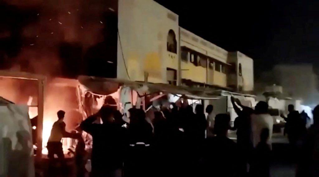Still picture obtained from a social media video shows Palestinians trying to extinguish fire after an Israeli air strike ...