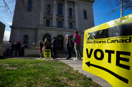 People line up outside a polling station to vote in Toronto