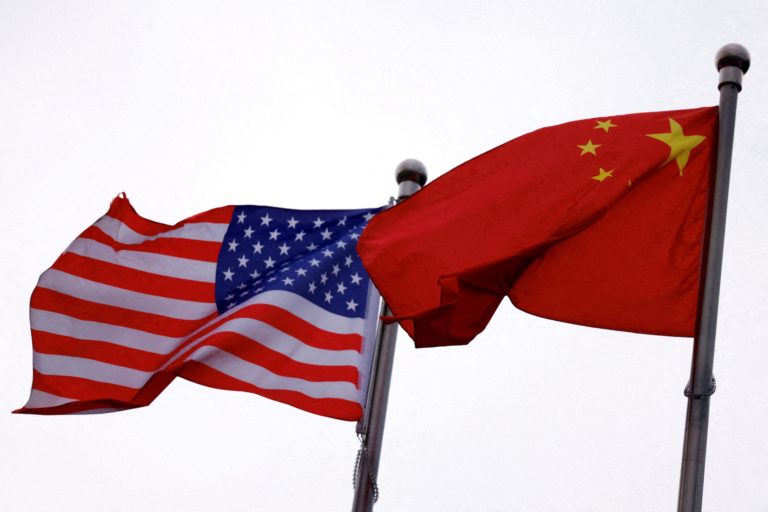 FILE PHOTO: Chinese and U.S. flags flutter outside the building of an American company in Beijing