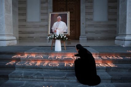 People offer candles after the death of Pope Francis in front of the Mother Teresa Cathedral, in Pristina