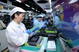 Workers work on a production line manufacturing smart automotive central control navigation products at a factory in Suqian