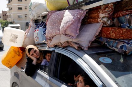 Palestinians make their way after fleeing areas around the southern city of Rafah, following an Israeli evacuation order, ...